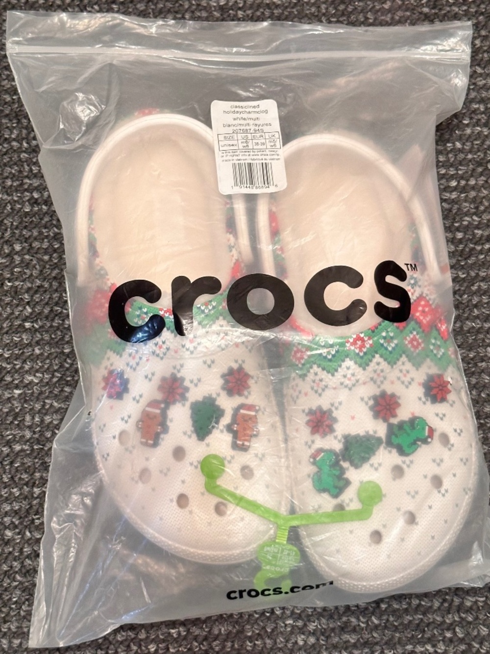 These are Crocs Classic Lined Holiday Charm Clogs featuring red and green colors